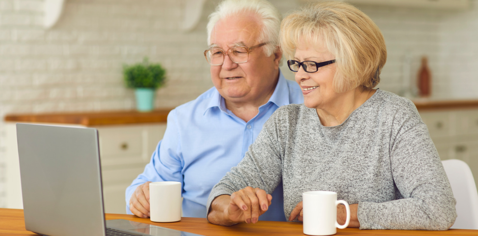 elderly couple looking at laptop